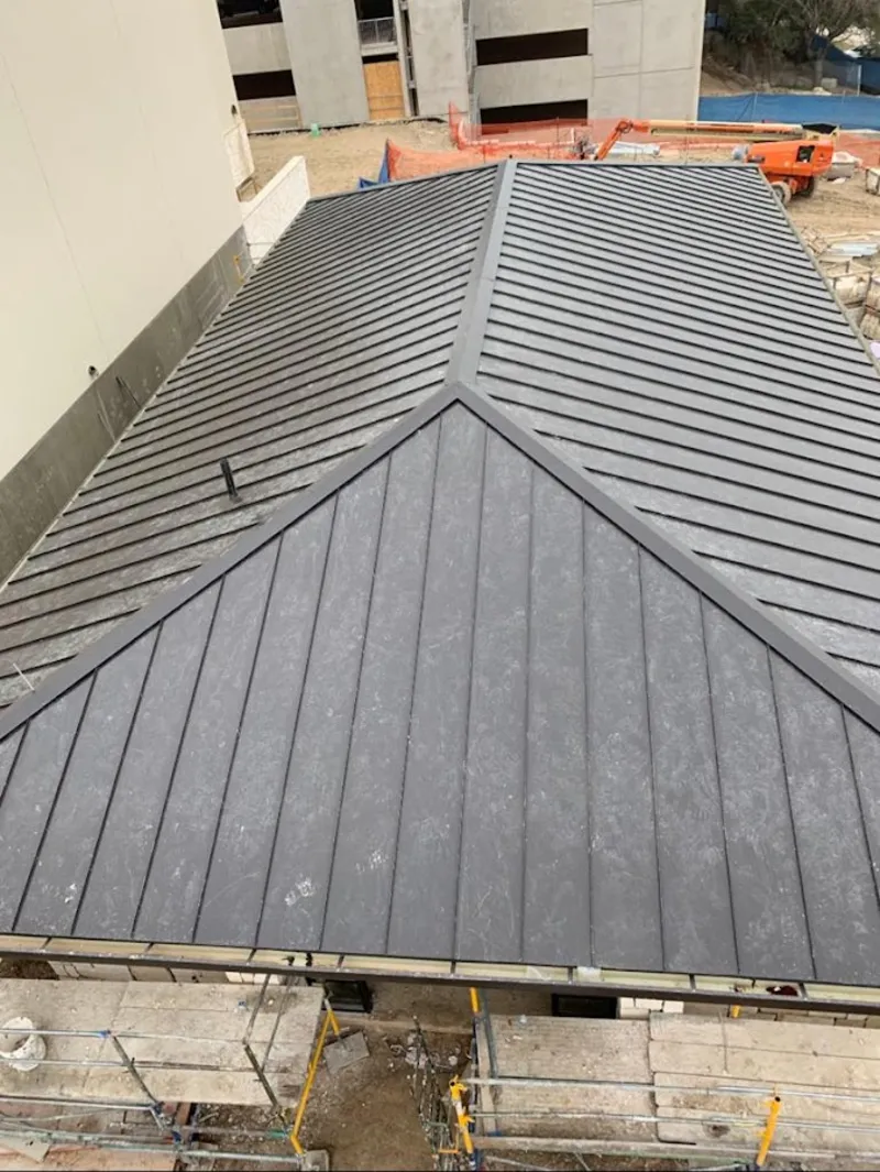 Commercial metal roof construction with crane equipment in Big Lake