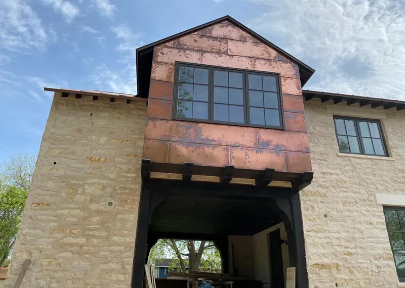 Copper metal panel facade on a stone building for Skylight Installation in Big Lake